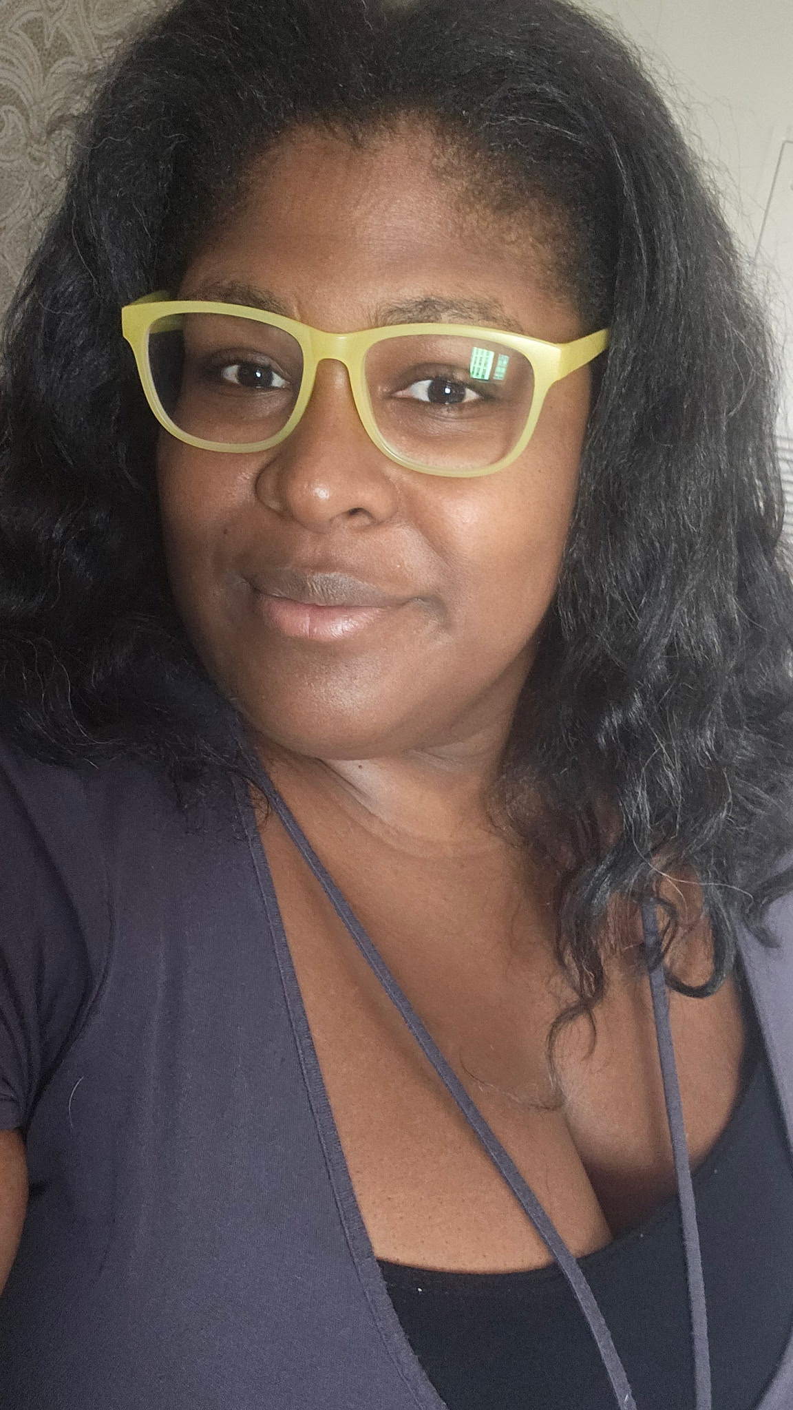 Kamaiya smiling in lime-green glasses